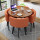 胡桃色の円卓、オレンジ色の布椅子、四つの椅子。